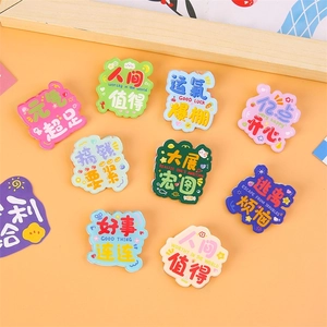 Collection of colorful acrylic pins with motivational quotes on a warm orange background
