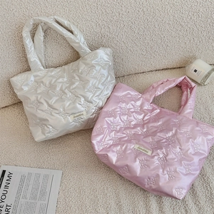 Close-up of quilted bow pattern tote bags in pearl white and soft pink colors