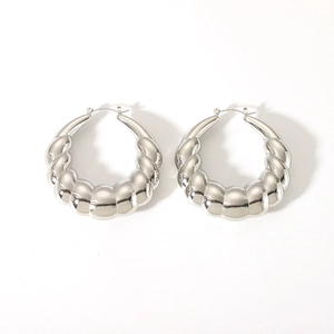 Detailed view of silver polished twist hoop earrings with textured ribbed design