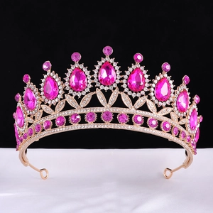 Macro detail of rose gold tiara featuring large magenta teardrop gems and clear rhinestones