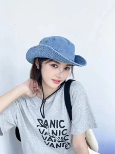 Détail d'un chapeau de soleil en denim à larges bords avec œillets et cordon réglable