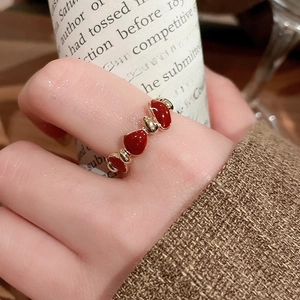 Close-up of a 14k gold plated heart-shaped red enamel open ring on a female finger