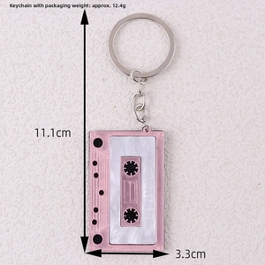 Pink cassette keychain details with 11.1cm length and 3.3cm width dimensions