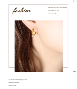Close-up of golden circular hoop earrings with sparkling cubic zirconia on a female model