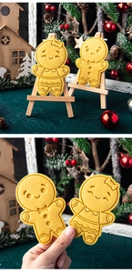 Close-up of two gingerbread man cookie cutters in yellow plastic for Christmas baking