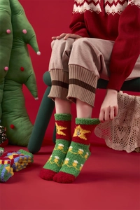 Close-up of thick coral fleece Christmas socks featuring reindeer and star patterns