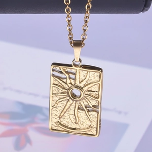Macro shot of rectangular sunburst pendant necklace with vintage gold texture and O-chain