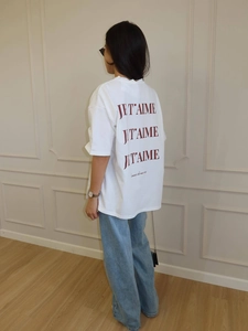Detail of white cotton T-shirt featuring red 'JE T'AIME' French slogan print on back