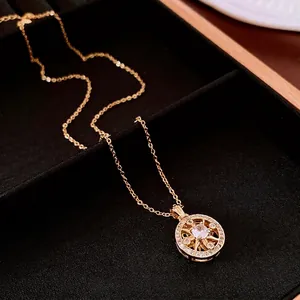 Gold plated round compass pendant necklace with shimmering zircon stones on black velvet