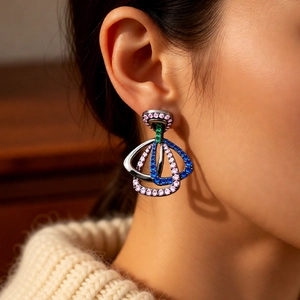 Gros plan de boucles d'oreilles vintage en forme d'éventail avec zircons colorés