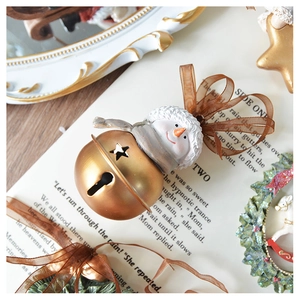 Detail of vintage Christmas snowman metal bell with resin head and brown organza ribbon