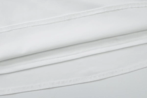 Detailed macro view showing the high-quality stitching on white jersey fabric dress