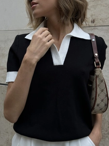 Polo noir en maille ajusté avec col contrasté blanc et décolleté en V élégant