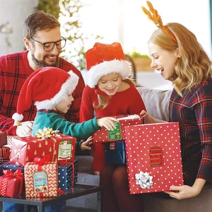 Family opening Christmas gifts decorated with festive adhesive labels and gift stickers