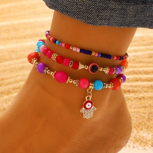 Set de tres tobilleras bohemias con cuentas, ojo turco y mano de Fátima en la playa
