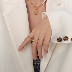 Ensemble bague texturée plaquée or 18K et collier de perles sur un modèle féminin