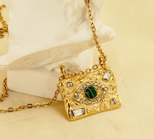 Detail of 18K gold necklace with malachite evil eye pendant on a white bust
