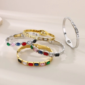 Detail of gold and silver bracelets featuring colorful square and round zircon gemstones