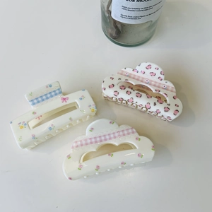 Three acrylic floral hair claws with blue and pink checkered patterns in cloud shapes