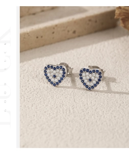 Macro shot of S925 silver heart stud earrings with blue and white zircon pavé details