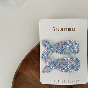 Pair of sequined mermaid tail hair clips for girls on display card with blue and pink scales