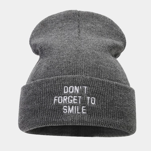 Detailed view of dark grey ribbed beanie featuring white embroidered slogan on the cuff