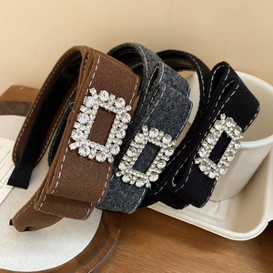 Close-up of velvet padded headbands with rhinestone buckles in black, gray, and brown