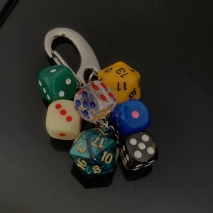 Close-up of metal keychain featuring colorful polyhedral and classic gaming dice charms