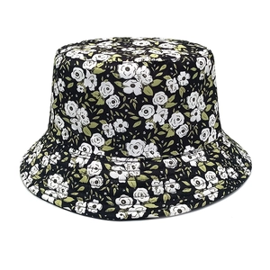 Close-up of floral bucket hat featuring white flower print on a black fabric background