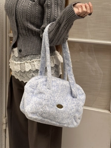 Gros plan sur un sac cabas en peluche bleu clair avec texture douce et logo vintage