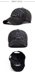 Dettaglio cappello da baseball in cotone nero lavato con ricamo bianco e bordi usurati