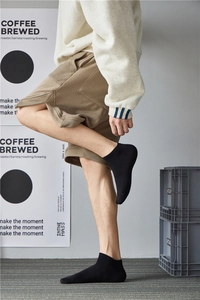 Close-up of a model wearing black cotton crew socks in a casual lifestyle setting