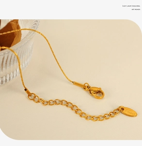 Detailed macro view of the gold stainless steel necklace lobster clasp and extender chain