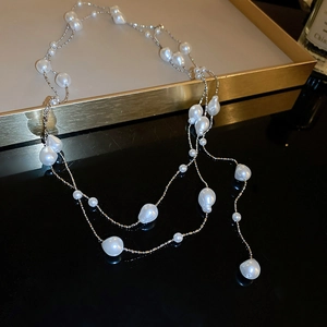 Detailed close-up of double-layer baroque pearl necklace on a luxury display tray