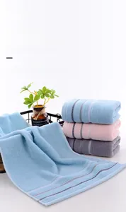 Detail of pure cotton hand towels with woven wave edges and hanging loops in home setting