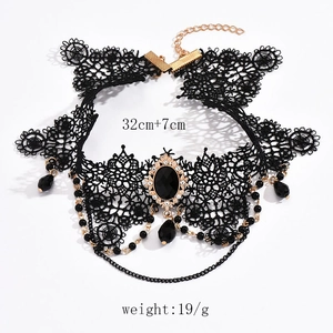 Detail of gothic black lace choker featuring layered rhinestones and a dark gemstone pendant