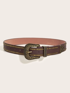 Dettaglio della cintura vintage in pelle marrone con fibbia in ottone sbalzato e borchie metalliche