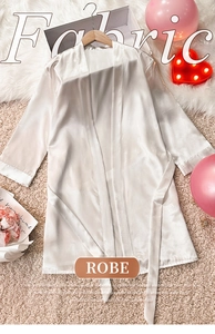 Detail of elegant white satin bathrobe featuring a smooth texture and matching waist tie