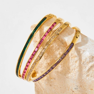 Luxury gold plated stainless steel bangles with colorful square cut gemstones on stone