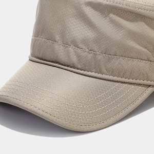 Detailed macro view of beige military cap with honeycomb mesh texture and reinforced stitching