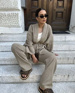 Detail of khaki linen wrap top and wide-leg trousers set worn by model on stairs