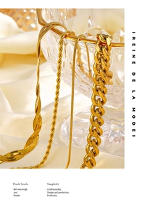 Detailed close-up of 18K gold plated Cuban and snake chain bracelets on silk fabric