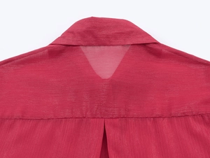 Détail macro du tissu en mousseline rouge texturé et du col arrière semi-transparent