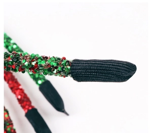 Close-up of glitter sequins and black knit tail protectors on a festive hairband