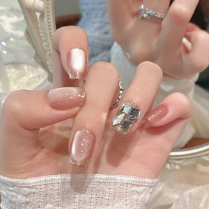 Detailed mirror view of pink-gold cat-eye press-on nails with silver glitter and rhinestones
