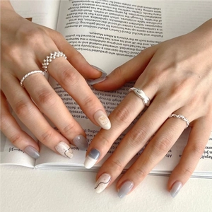 Detailed view of silver minimalist stacked ring set with pearls on an open book background