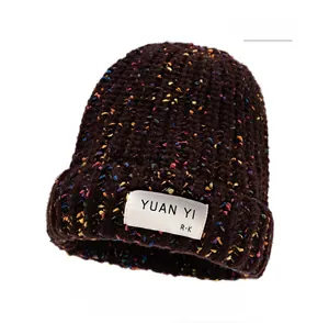 Detail of coffee knit beanie featuring multi-color specks and a stitched square label