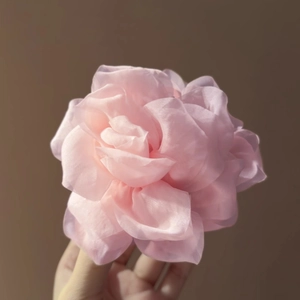 Dettaglio della molletta rosa in tessuto con trama realistica di fiori di seta