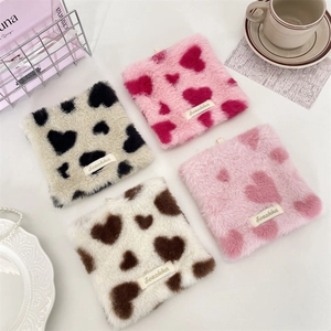 Detailed view of square plush coasters with heart patterns and soft furry texture