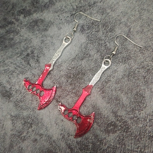 Close-up of blood-splattered silver axe pendant earrings with a sharp metallic finish
